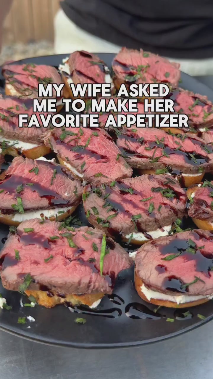 Steak crostini grilled on a portable charcoal grill.