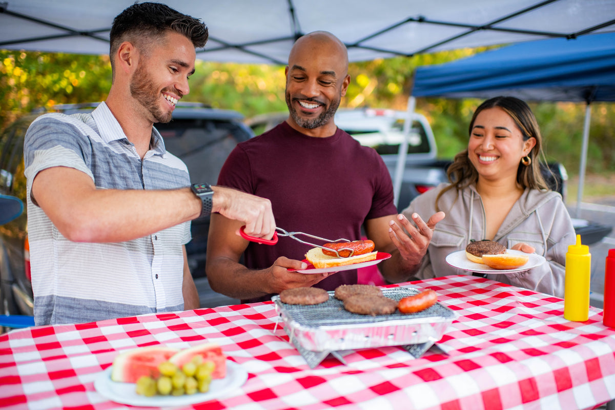 Friends using Pull Start Fire Grill at a picnic with food 