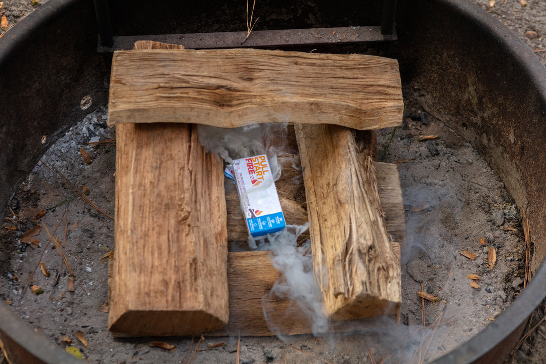 Smoking Pull Start Fire log starter beginning to ignite wet wood